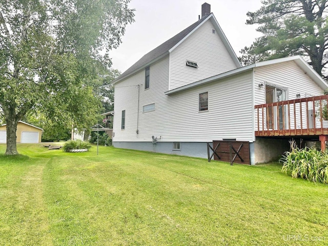 back of house featuring a wooden deck, a yard, and an outdoor structure