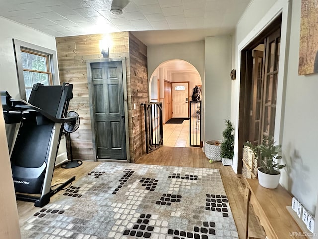 exercise area featuring wood walls and light hardwood / wood-style floors