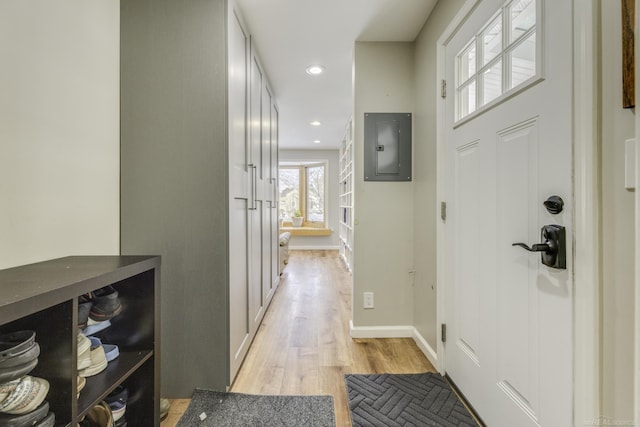 hallway with electric panel and light wood-type flooring