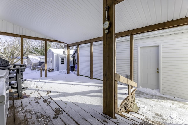 snow covered deck with a storage shed