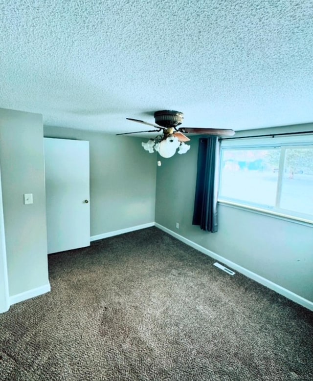 carpeted spare room with ceiling fan and a textured ceiling