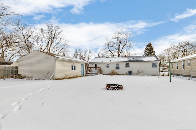 snow covered house featuring central AC unit and a fire pit