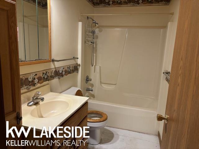 full bathroom featuring shower / tub combination, vanity, toilet, and tile patterned flooring