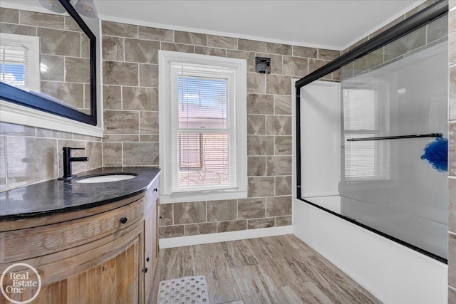 bathroom with hardwood / wood-style floors, a wealth of natural light, tile walls, and crown molding