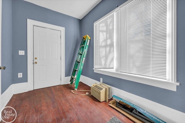 interior space featuring a wall mounted air conditioner and dark hardwood / wood-style flooring