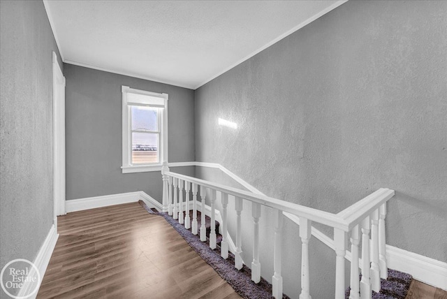 staircase featuring wood-type flooring and ornamental molding