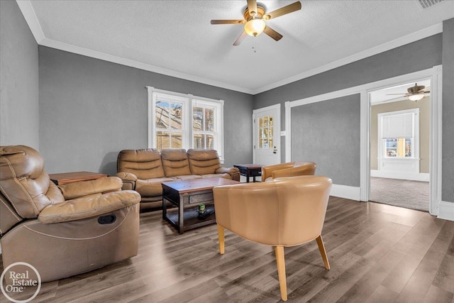 living room featuring ceiling fan, ornamental molding, a textured ceiling, and hardwood / wood-style flooring