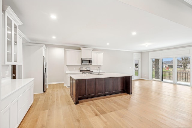 kitchen with white cabinets, crown molding, sink, light wood-type flooring, and stainless steel appliances