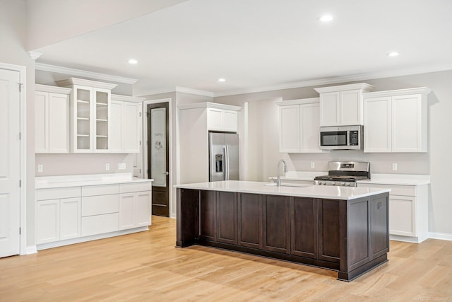 kitchen featuring a center island with sink, sink, light hardwood / wood-style flooring, appliances with stainless steel finishes, and white cabinetry