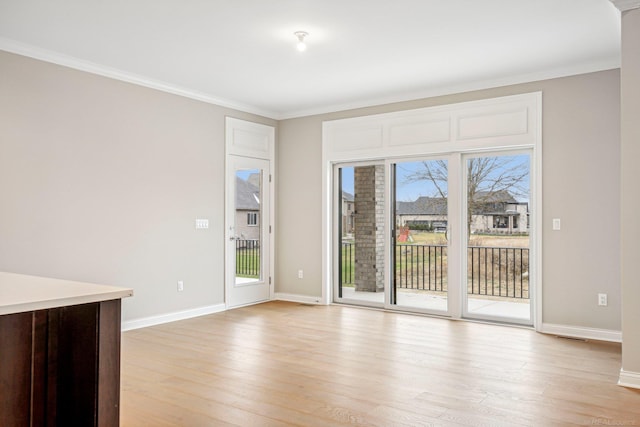 spare room with light hardwood / wood-style floors and ornamental molding