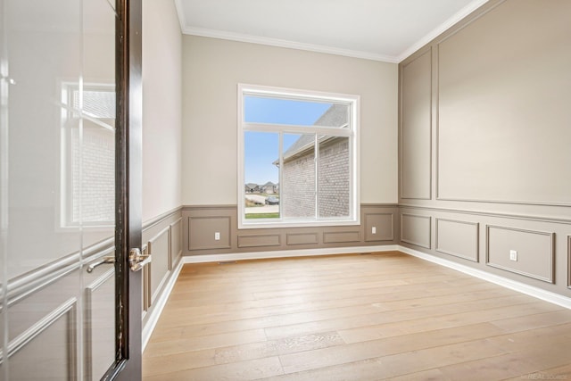 unfurnished room featuring light wood-type flooring and crown molding