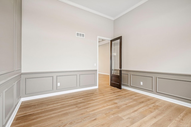 spare room with light wood-type flooring and ornamental molding