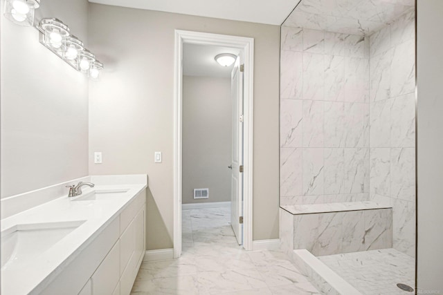 bathroom featuring tiled shower and vanity