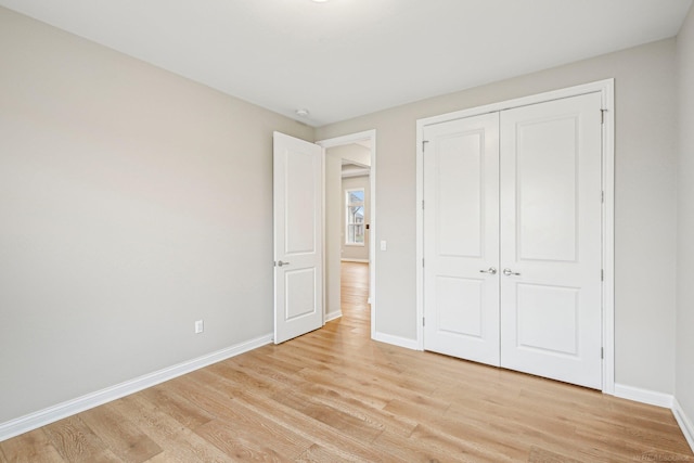 unfurnished bedroom with light hardwood / wood-style floors and a closet