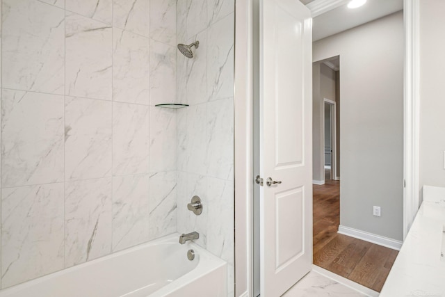 bathroom featuring wood-type flooring, vanity, and tiled shower / bath