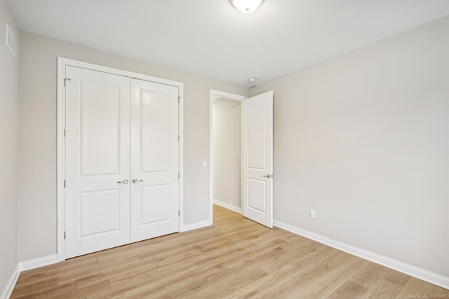 unfurnished bedroom featuring a closet and light hardwood / wood-style flooring