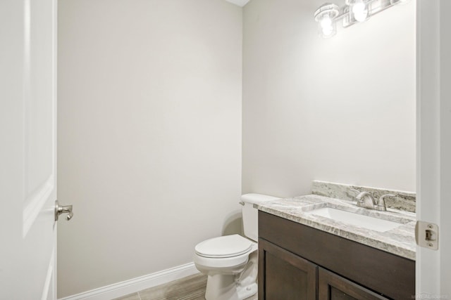 bathroom with vanity, wood-type flooring, and toilet