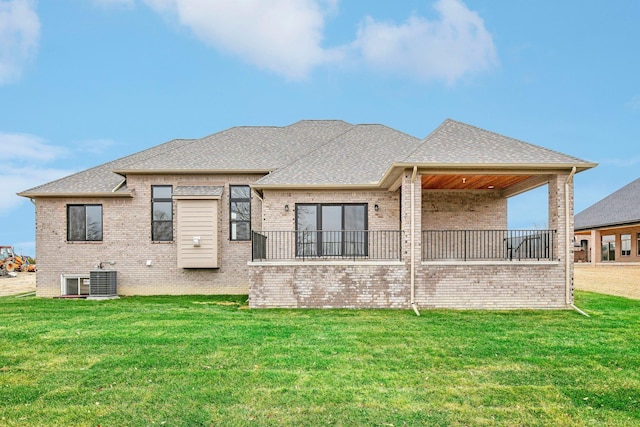 rear view of property with a lawn and central air condition unit