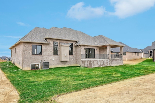 back of house featuring central AC unit and a lawn