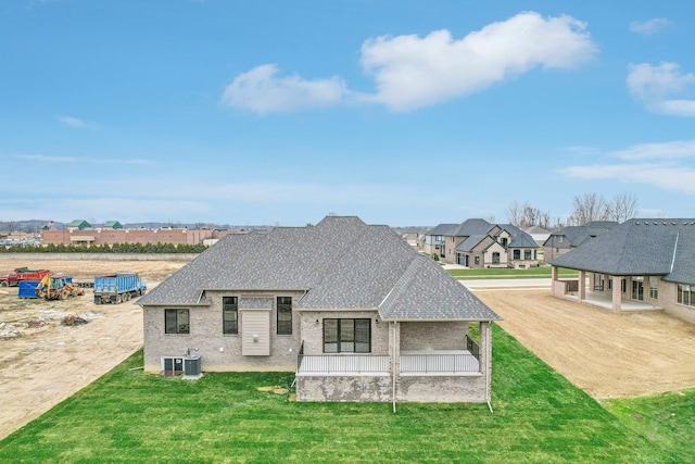 back of house with a lawn, covered porch, and central AC unit