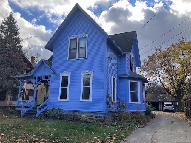 victorian house featuring covered porch and a front lawn