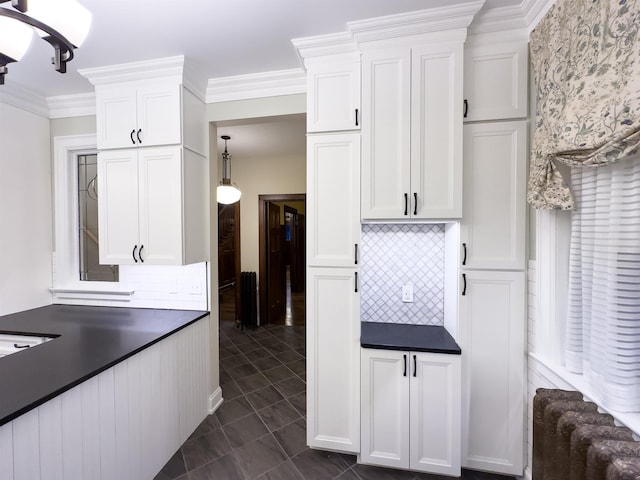 kitchen with white cabinets, decorative backsplash, ornamental molding, and hanging light fixtures