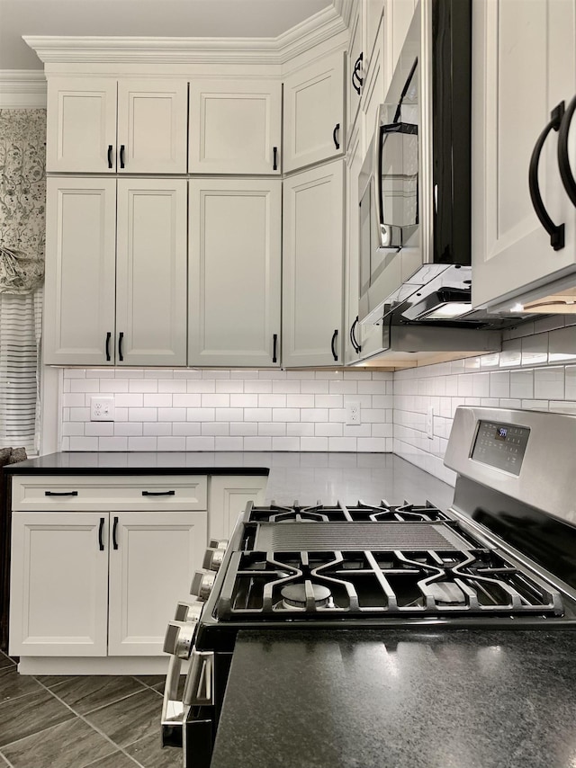 kitchen featuring decorative backsplash, appliances with stainless steel finishes, white cabinets, and ornamental molding