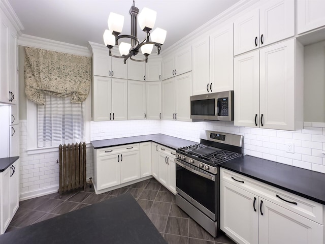 kitchen with radiator heating unit, stainless steel appliances, and white cabinetry