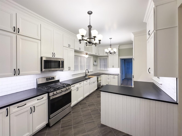 kitchen with white cabinetry, tasteful backsplash, a notable chandelier, decorative light fixtures, and appliances with stainless steel finishes