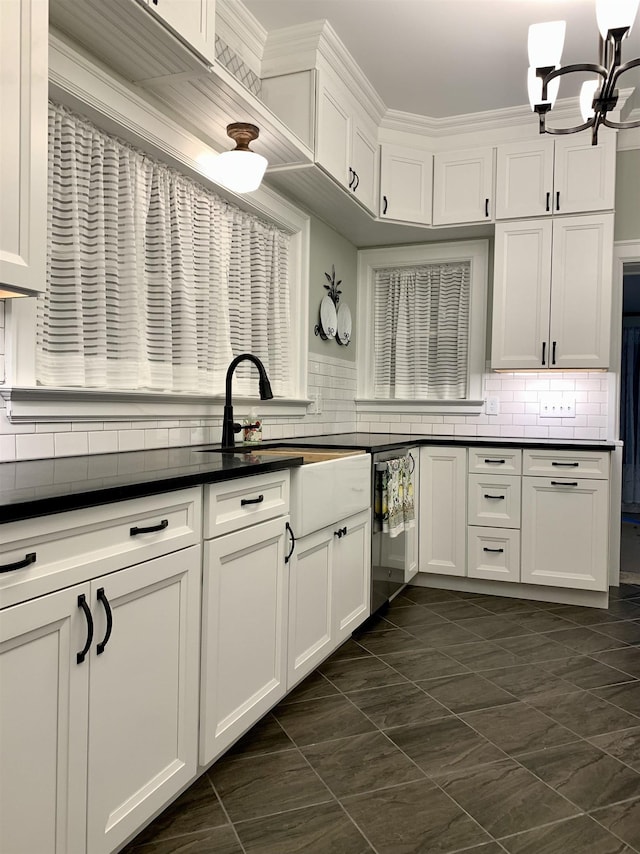 kitchen with decorative backsplash, white cabinetry, stainless steel dishwasher, and ornamental molding