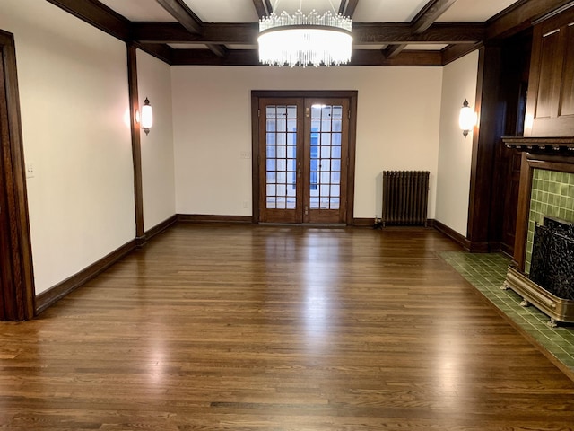 unfurnished living room featuring french doors, dark hardwood / wood-style flooring, radiator, coffered ceiling, and beamed ceiling