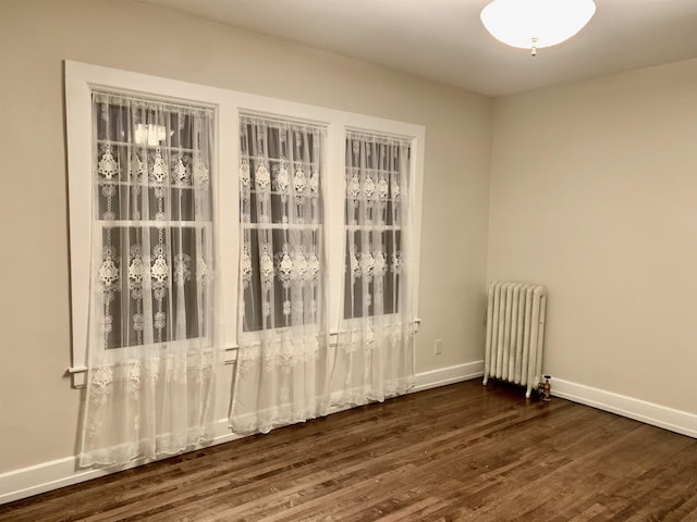 empty room with radiator and dark wood-type flooring