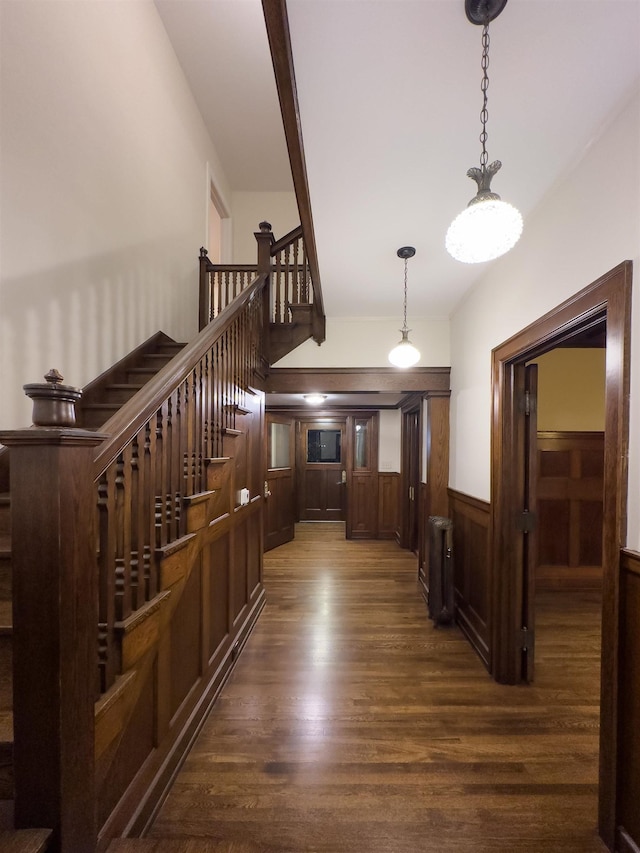 hall featuring wood walls, dark hardwood / wood-style flooring, and radiator heating unit