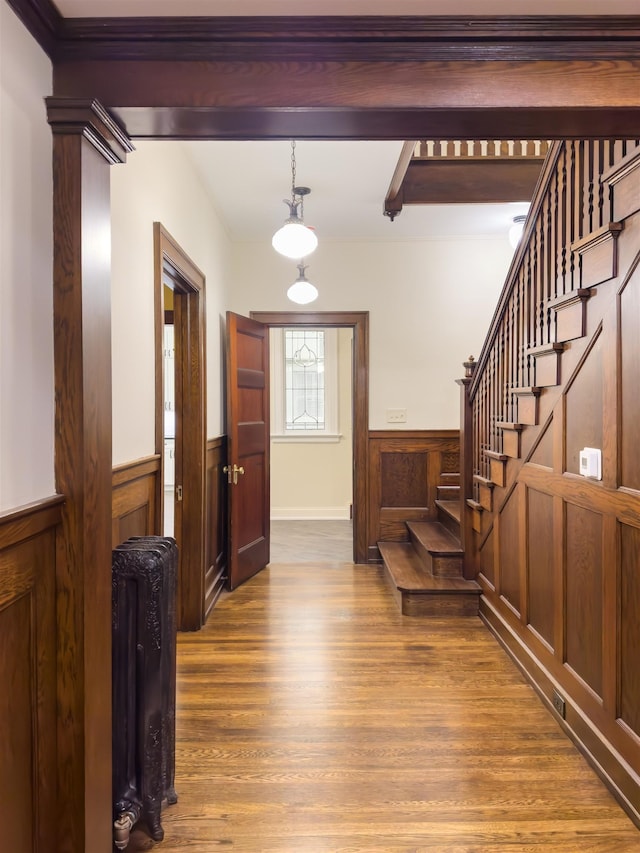 foyer entrance featuring beam ceiling, wooden walls, and hardwood / wood-style floors