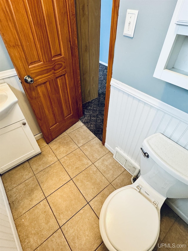 bathroom with tile patterned flooring, vanity, and toilet