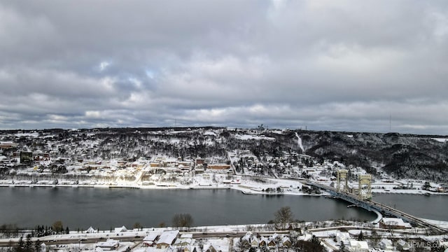 snowy aerial view featuring a water and mountain view