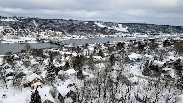 snowy aerial view with a water and mountain view