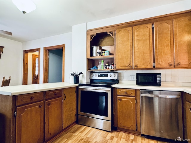 kitchen with backsplash, kitchen peninsula, stainless steel appliances, and light hardwood / wood-style flooring