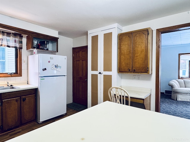 kitchen with sink, dark hardwood / wood-style flooring, and white refrigerator