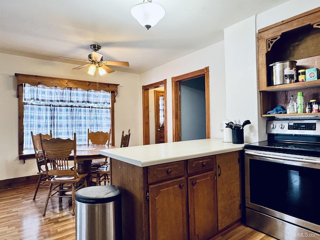 kitchen featuring dark brown cabinets, light hardwood / wood-style floors, electric stove, and kitchen peninsula