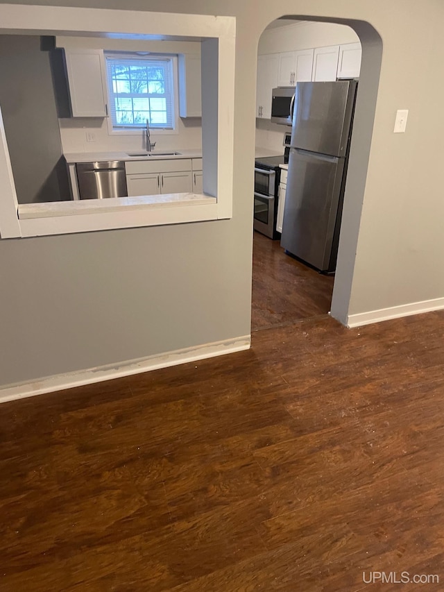 kitchen with sink, white cabinets, dark hardwood / wood-style floors, and appliances with stainless steel finishes