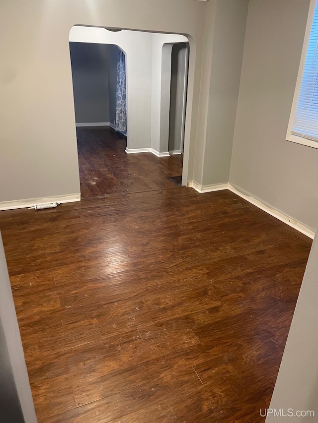 unfurnished room with dark wood-type flooring