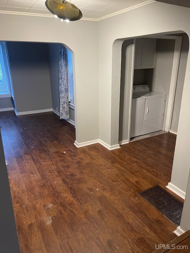 hallway with dark hardwood / wood-style flooring, washing machine and dryer, and crown molding