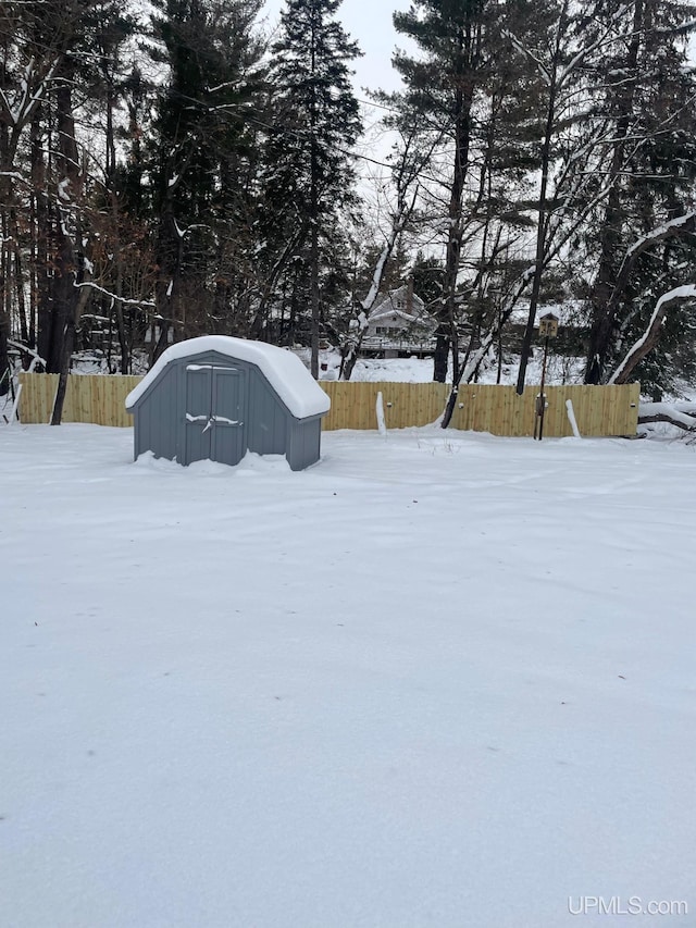 yard covered in snow featuring a shed