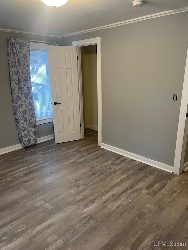 unfurnished room featuring dark hardwood / wood-style flooring and ornamental molding