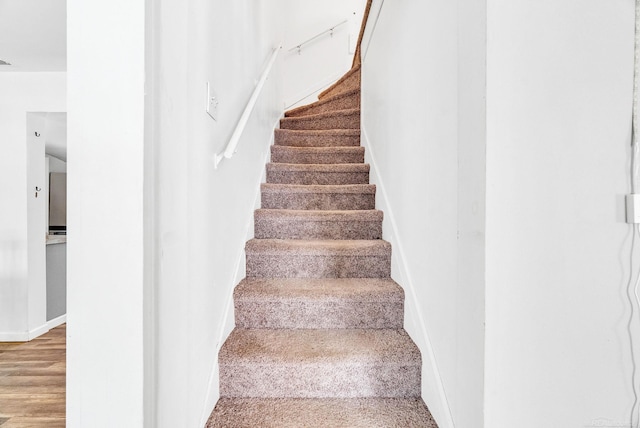 stairway with hardwood / wood-style flooring