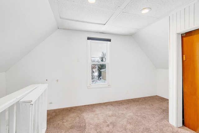 additional living space featuring lofted ceiling and light carpet