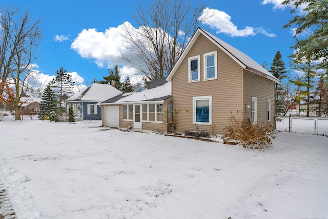 snow covered house featuring a garage