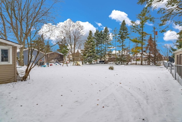 yard covered in snow with a playground