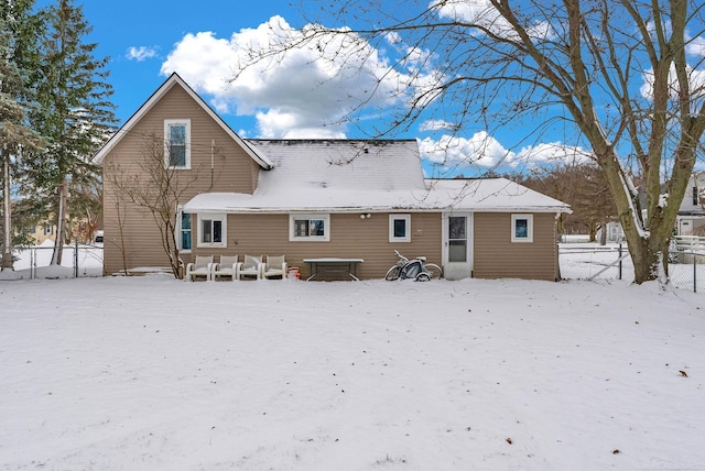 view of snow covered back of property